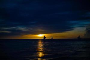 Small sailboat on the beautiful sunset in Philippines photo