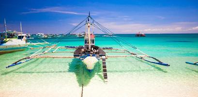 Boat at the white beach with turquoise water in Boracay, Philippines photo