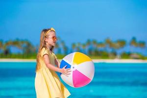 adorable niña jugando con juguetes de playa durante las vacaciones tropicales foto