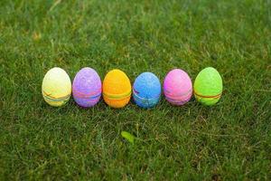 Multi-colored Easter eggs on green grass photo