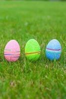 Multi-colored Easter eggs on green grass photo