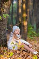 Adorable little girl outdoors at beautiful autumn day photo