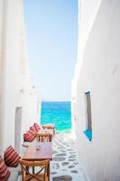 bancos con almohadas en un típico café griego al aire libre en mykonos con impresionantes vistas al mar en las islas cícladas foto