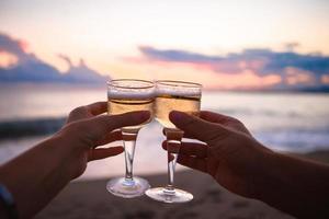 two glasses on the white sandy beach photo