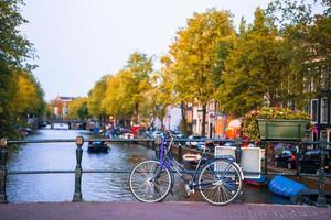 Bikes on the bridge in Amsterdam, Netherlands. Beautiful view of canals in autumn photo
