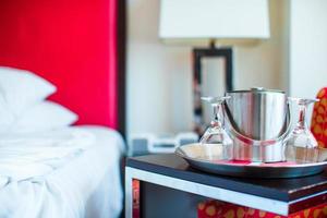 dormitorio romántico con copas de vino y cubo de hielo en el interior de un hotel de lujo foto