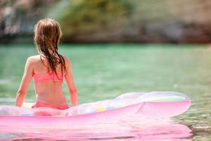 adorable chica en un colchón de aire inflable en el mar foto