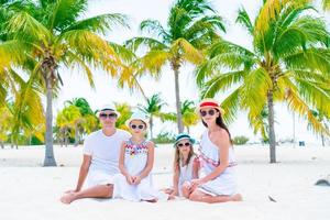 Family of four on white beach photo