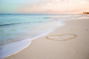 Heart drawn in the sand. Beach background. Top view photo