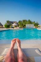 Female feet outdoors during summer vacation. Woman relax near pool photo