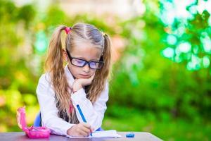 Little happy girl with pencils outdoors. Back to school. photo