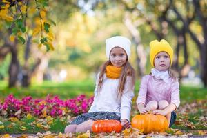 niñas felices con calabazas listas para halloween al aire libre en el hermoso día de otoño. truco o trato foto