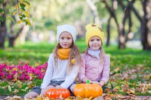 concepto de halloween - niñas en otoño hermoso parque con calabazas foto