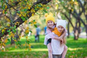 Little adorable girls outdoors at warm sunny autumn day photo