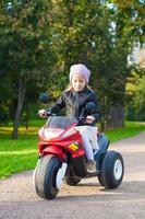 niña adorable divirtiéndose en su motocicleta de juguete foto