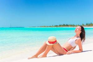 Young woman on a tropical beach with hat photo