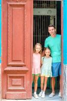 retrato de familia feliz mirando por la puerta a viejos apartamentos en la habana foto