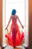 Young beautiful woman in red dress on old balcony in apartment in Old Havana, Cuba. photo