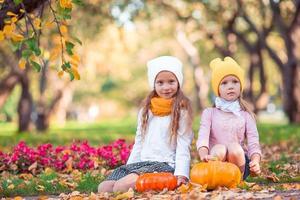 niñas adorables con calabaza al aire libre en un cálido día de otoño. foto