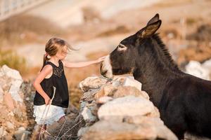 Little girl with donkey on the island of Mykonos photo