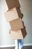 Happy girl moving in new house with cardboard boxes photo