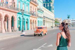 mujer feliz en zona popular en la habana vieja, cuba. chica joven viajero fondo coloridas casas foto