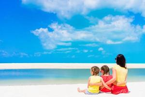 Adorable little girls and young mother on white beach photo