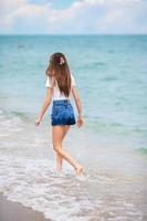 Back. view of happy girl running on the beach photo