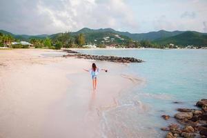 Young happy woman on white beach walking photo