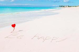 Red heart with yarn on sand beach background for Valentine's day. photo