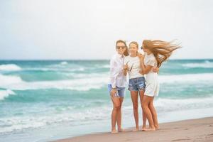 Adorable little girls and young mother on tropical white beach photo