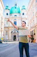 Man tourist with a city map in Europe street. Caucasian boy looking with map of European city. photo