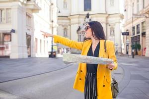 Young woman with city map in city. Travel tourist girl with map in Vienna outdoors during holidays in Europe. photo