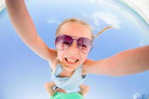 Little girl outdoors during summer vacation have fun with father. Portrait of a kid upside down on a sky background photo