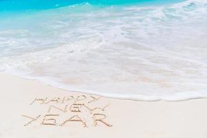 Inscripción de 2018 escrita en la playa de arena, tarjeta de felicitación de año nuevo. foto