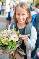 Adorable smilling little girl posing in front of their school. Adorable little kids feeling very excited about going back to school photo