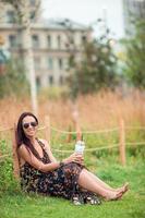 Happy young urban woman drinking coffee outdoors photo