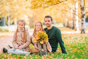 Family of dad and kids on beautiful autumn day in the park photo