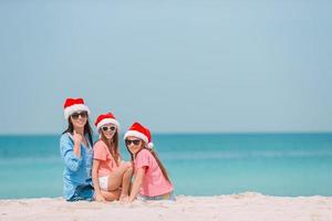 Adorable little girls and young mother on tropical white beach photo