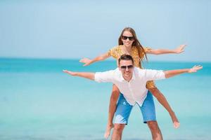 Little girl and happy dad having fun during beach vacation photo