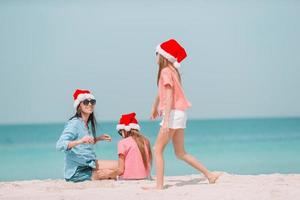 Adorable little girls and young mother on tropical white beach photo