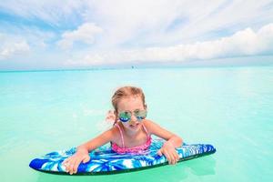 Little girl relaxing on inflatable air mattress in the sea photo