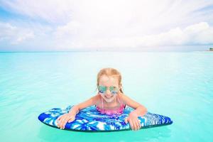 Little girl relaxing on inflatable air mattress in the sea photo