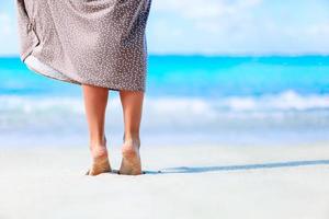 Young woman sunbathing on white beach. Legs. photo