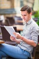 Caucasian man reading papers outdoors on the street. photo