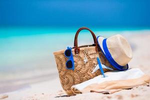 Beach consept - straw bag, hat, sunglasses and towel on white beach photo