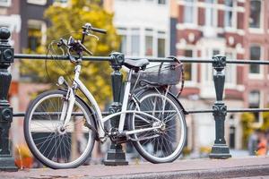 Bike on the bridge in Amsterdam, Netherlands. Beautiful view of canals in autumn photo