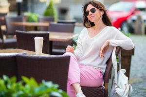 joven caucásica escuchando música en un café al aire libre foto