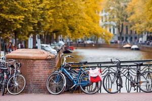 Bike on the bridge in Amsterdam, Netherlands. Beautiful view of canals in autumn photo