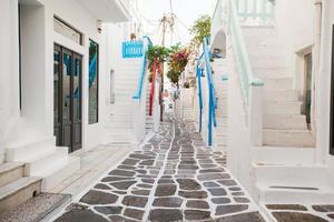 The narrow streets of greek island with cat. Beautiful architecture building exterior with cycladic style. photo